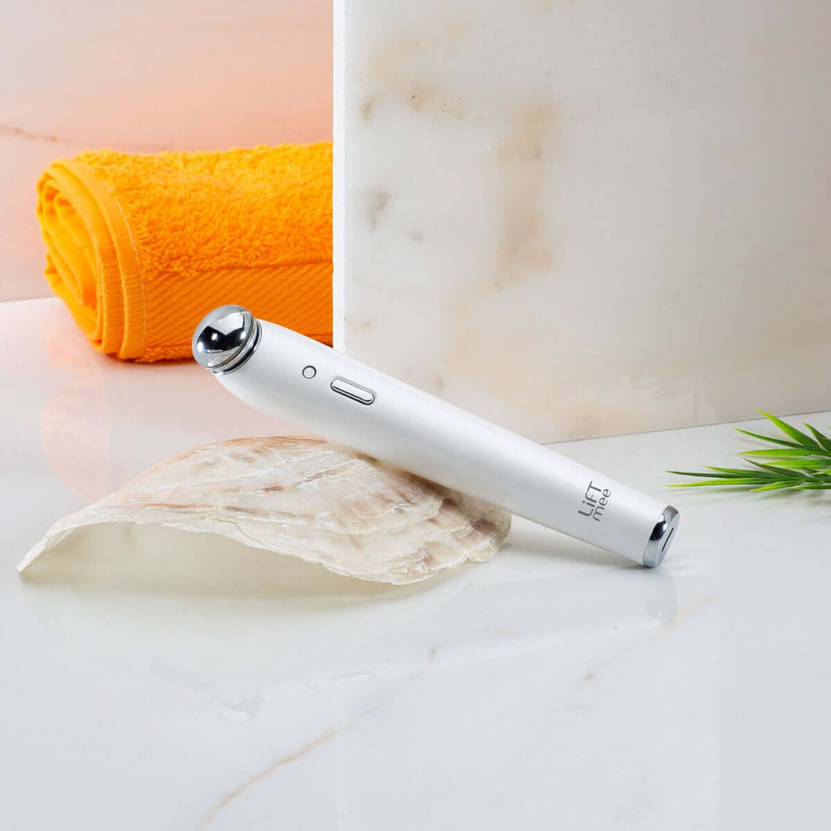 LiFTmee IONIC Beauty Light on marble surface with towel, enhancing skincare with ionic technology.