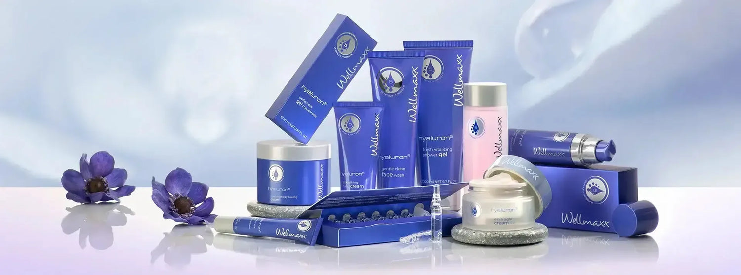 A collection of wellness skincare products in blue packaging, featuring creams, tubes, and jars with floral accents.