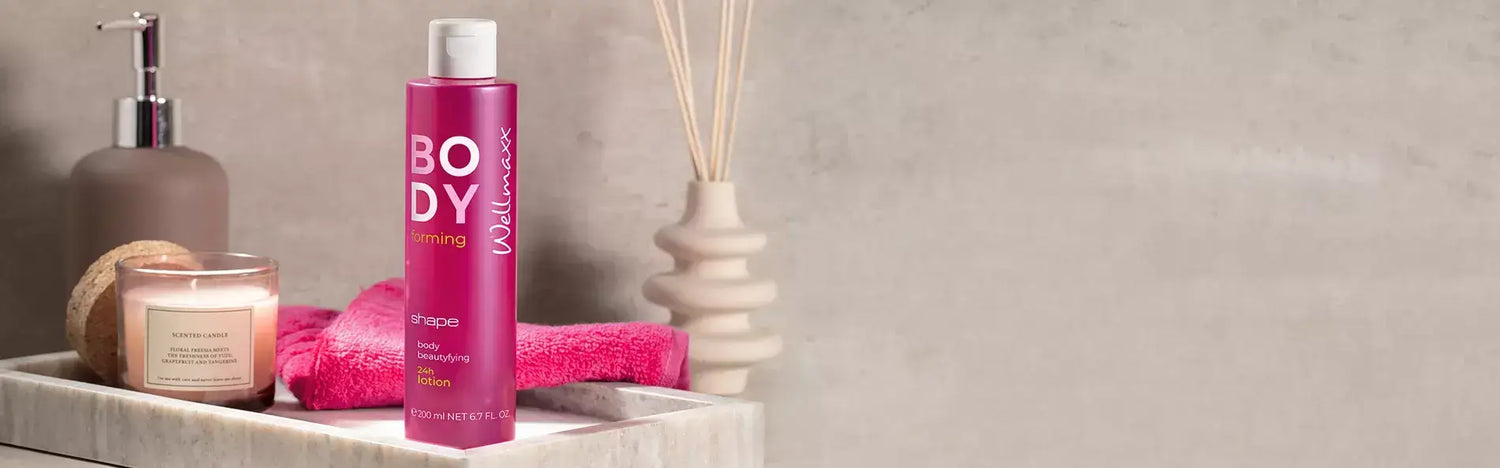 Luxury body care products on a spa-inspired bathroom counter, showcasing a pink body lotion and candles.