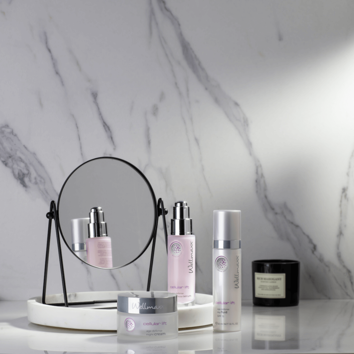 Set of skincare products including cellular lift age defense night cream on a marble background with a mirror.