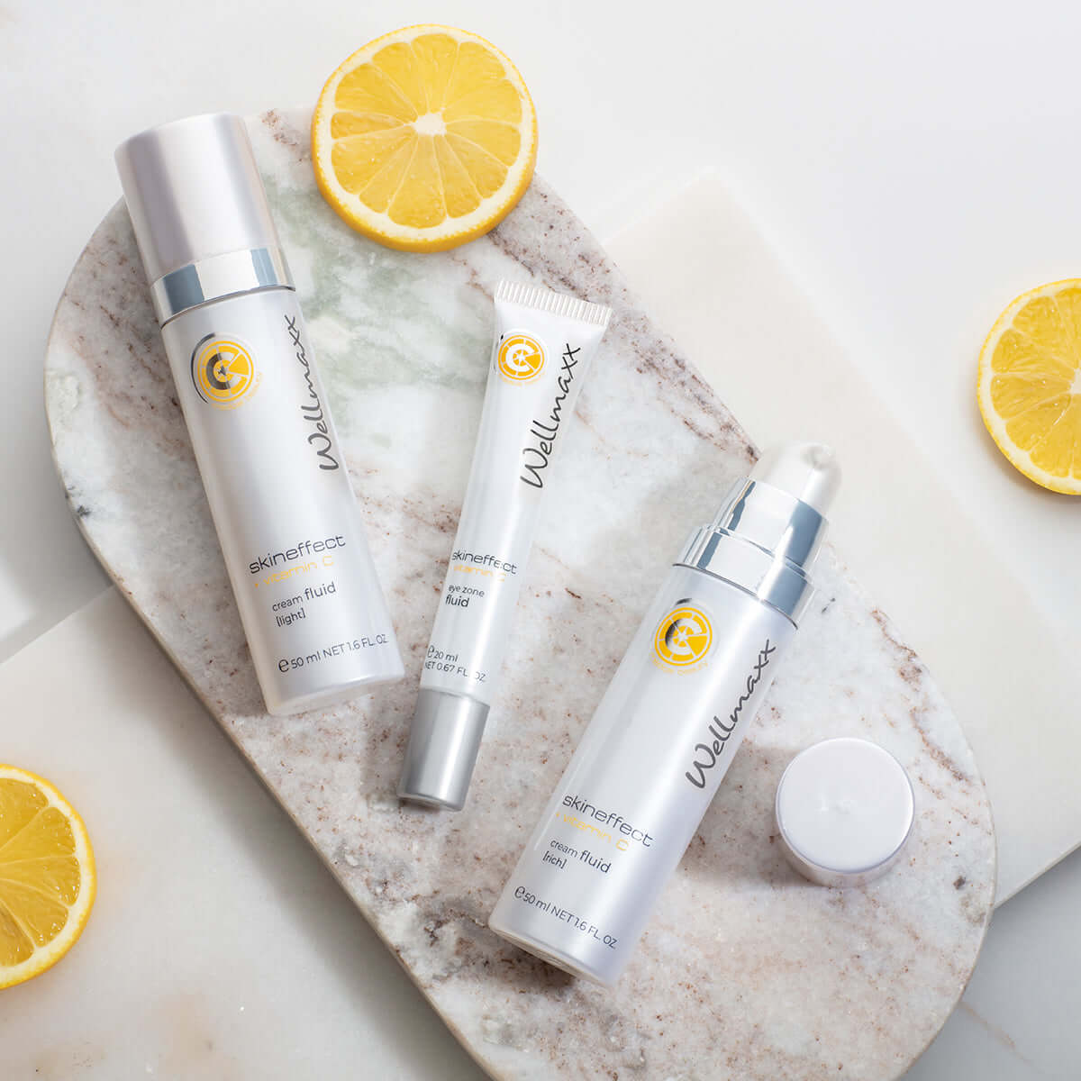 skineffect vitamin C cream fluid products displayed with fresh lemons on marble surface for skincare rejuvenation.