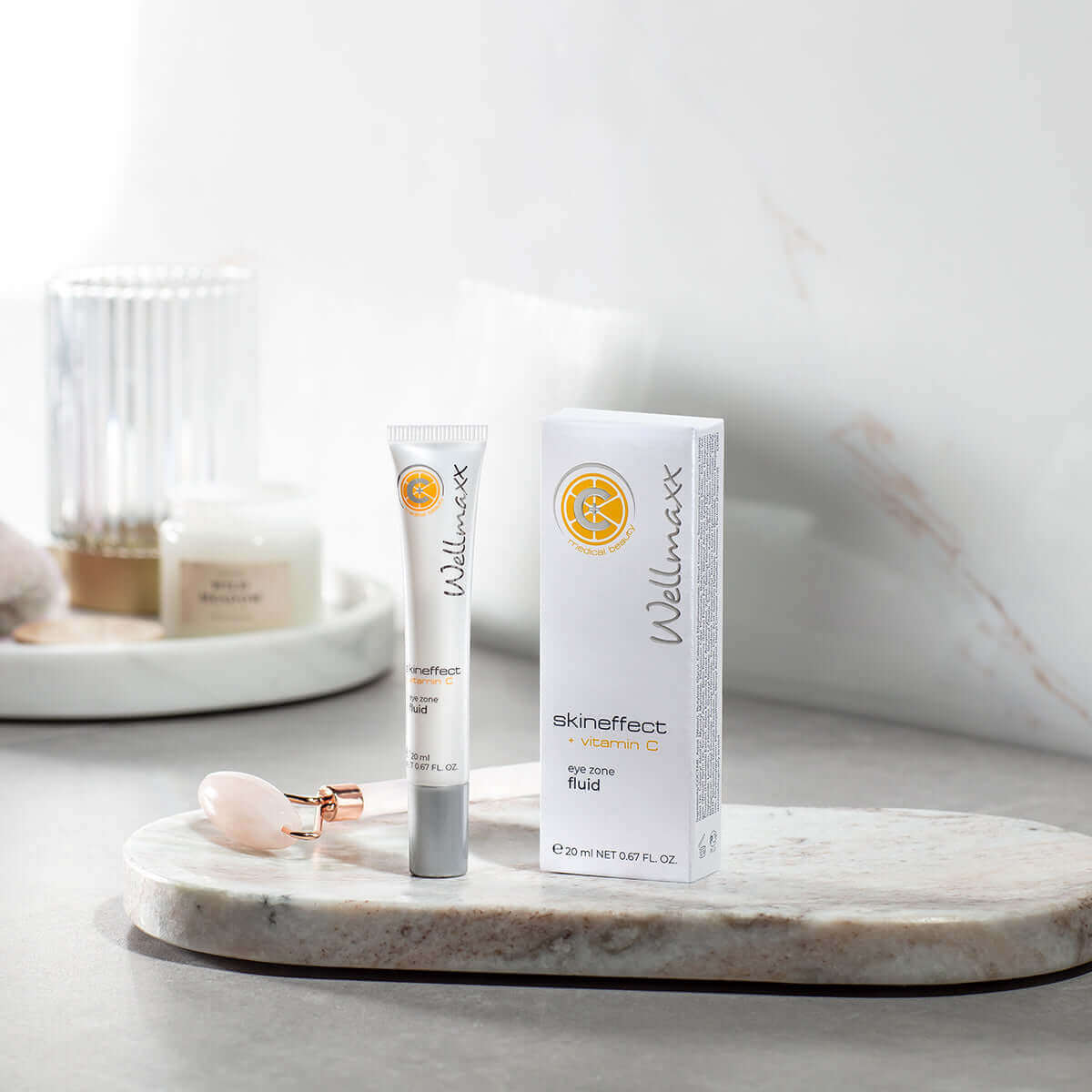Wellmaxx skin effect vitamin C fluid displayed on a marble tray with skincare accessories.