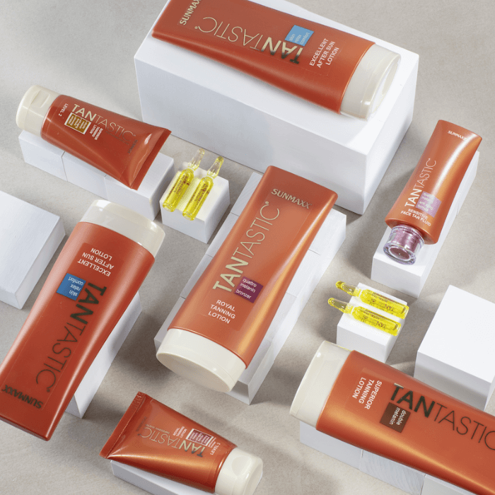 TanTastic Sensitive Face Tan Fluid and other products displayed elegantly on a light background.