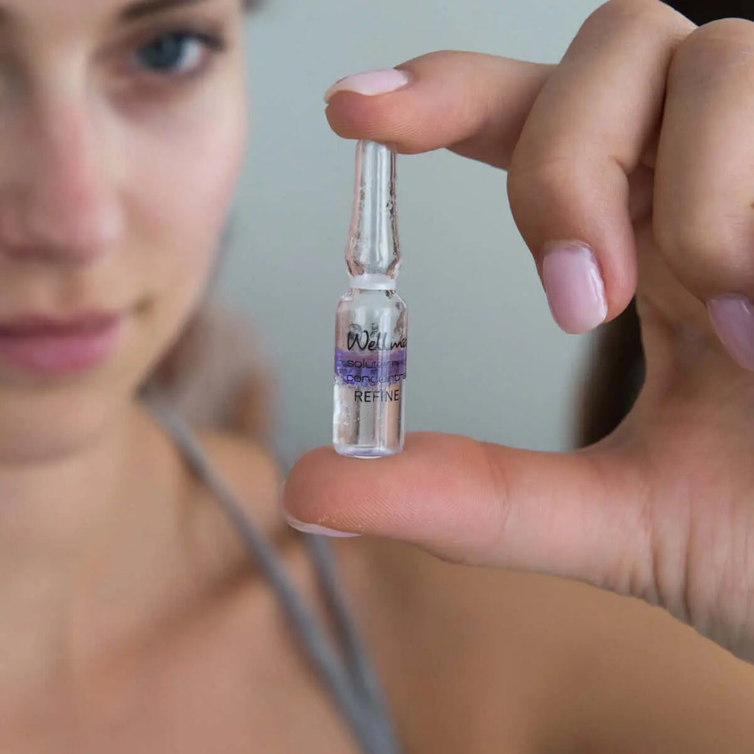 Frau hält eine Ampulle mit Syn®-Ake synthetisches Peptid - aus dem Gift der Tempelviper in der Hand.