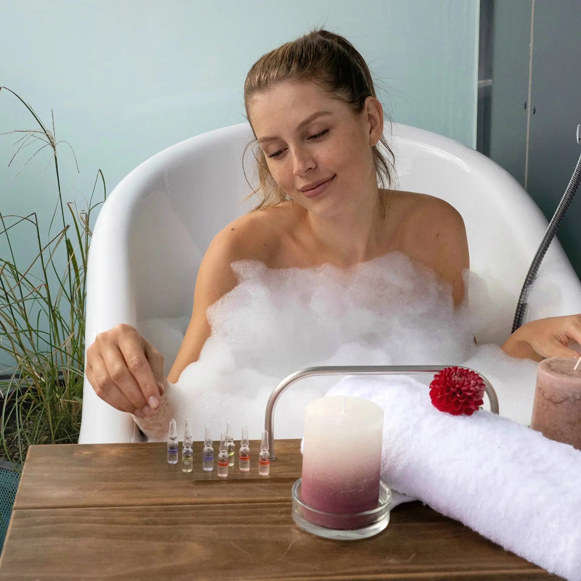 Frau im Bad mit Ampullen & Konzentrate für sofort sichtbare Ergebnisse in einem entspannenden Spa-Setting.